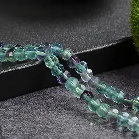 Button strand, fluorite, 05 x 06mm, faceted | wholesaler gems & healing stones