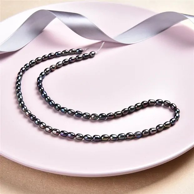 Strand of rice grain, freshwater pearl, petrol (dyed), 05-06 x 03-04mm | Marco Schreier