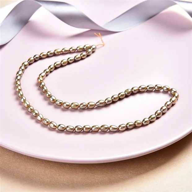 Rang de collier grain de riz, perle d'eau douce, jaune-vert (teintée), 06-07mm | Marco Schreier