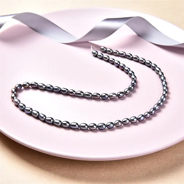 Rang de collier grain de riz, perle d'eau douce, pétrole (teintée), 06-07 x 04-05mm | Marco Schreier