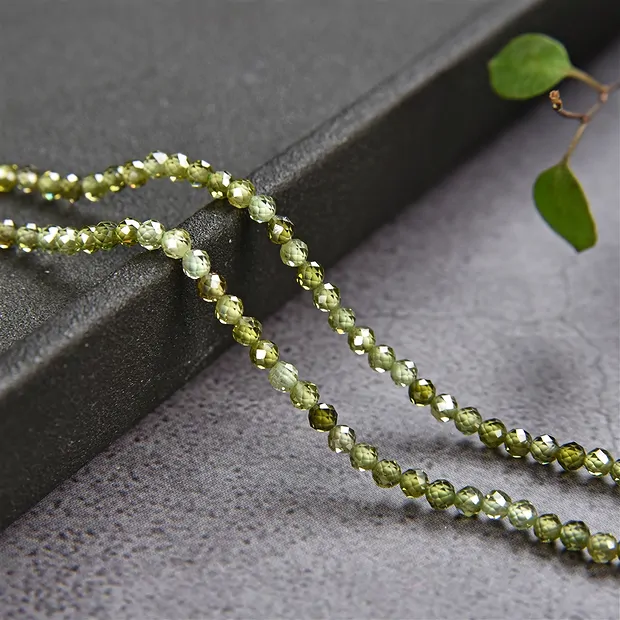 Cuentas de piedras preciosas, Circonia cúbica verde (sint.), facetada, 03mm (38cm) | Marco Schreier